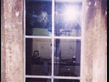窓に写る不気味な顔 - 心霊写真